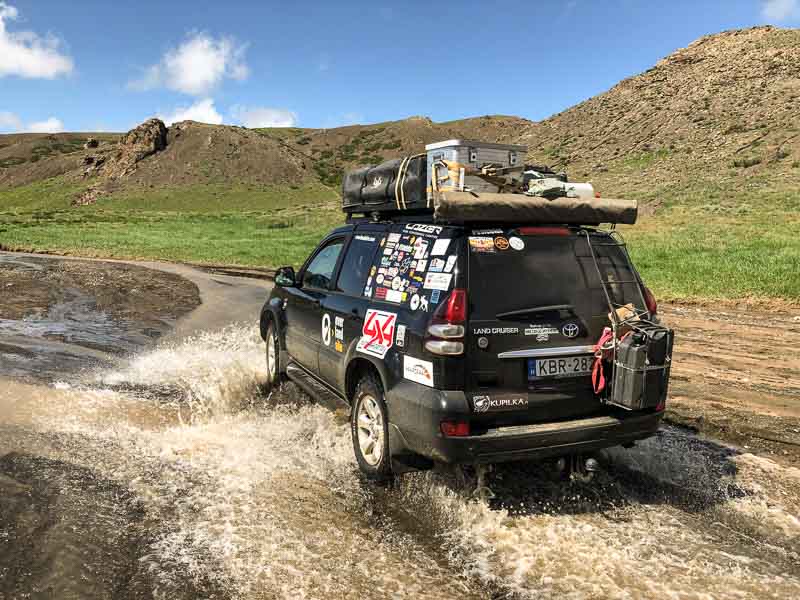 overlanders in riverbed toyota prado in river