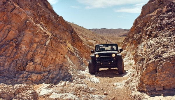 Overlanding Jeep between rocks in desert